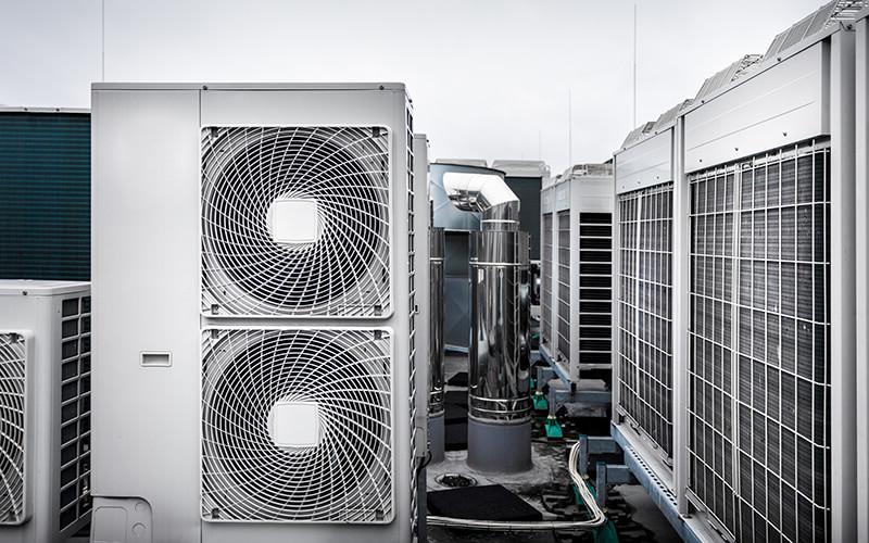Square air-conditioning units with round fan grills on the roof